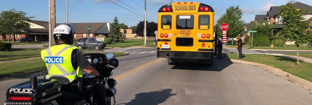 motorcycle officer and school bus