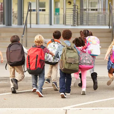 a group of kids walking into a school