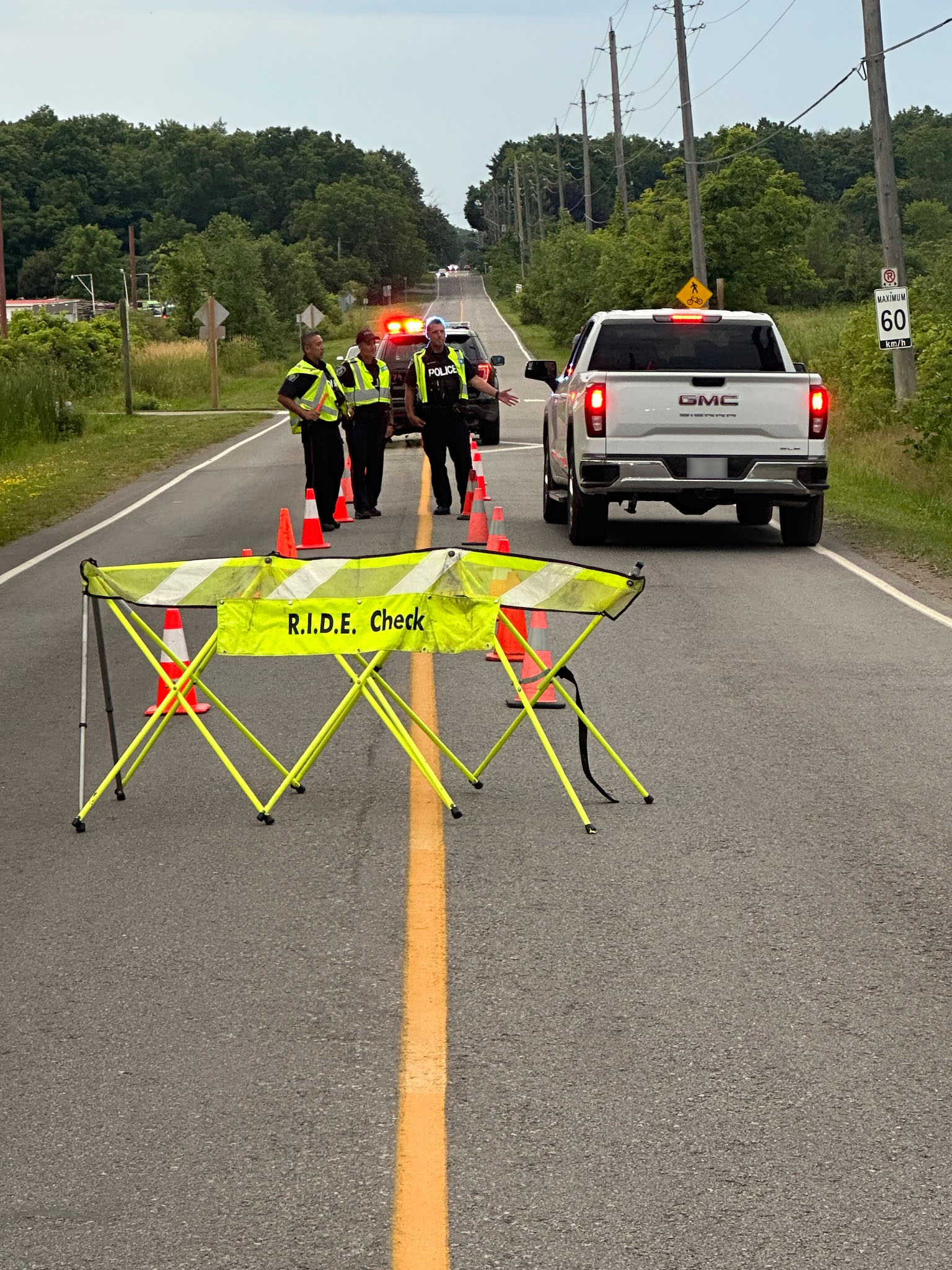 A ride program during the day with police officers stopping a pick up truck
