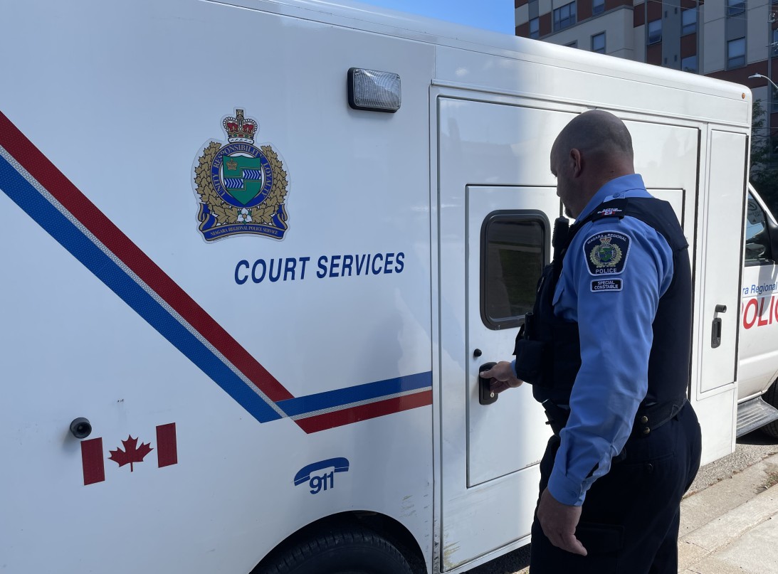 A special constable opening the door to a prisoner transport vehicle