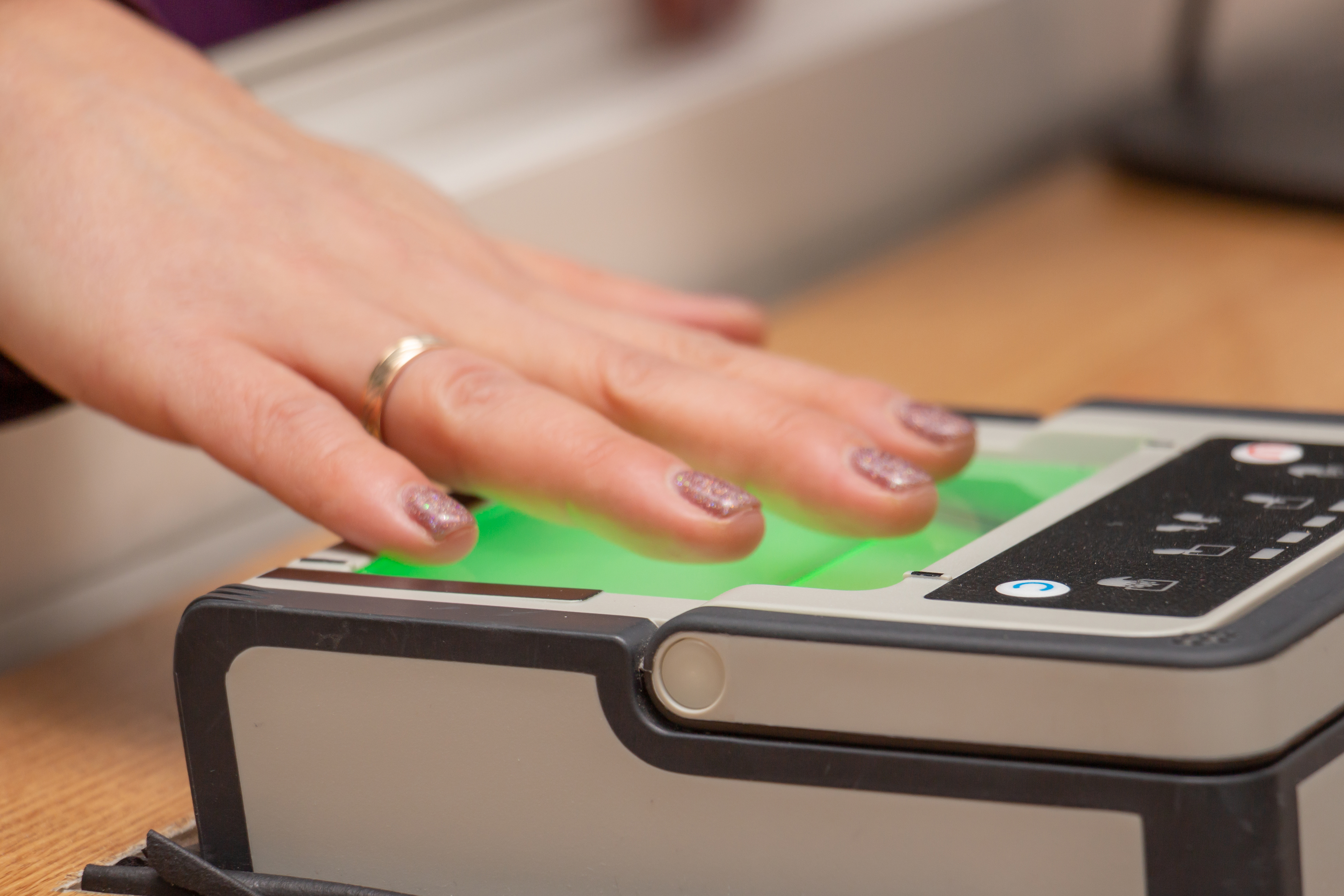 A hand on a a fingerprint scanner