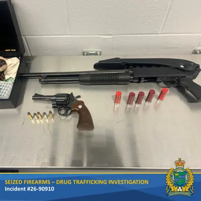 Two guns on a table with ammunition