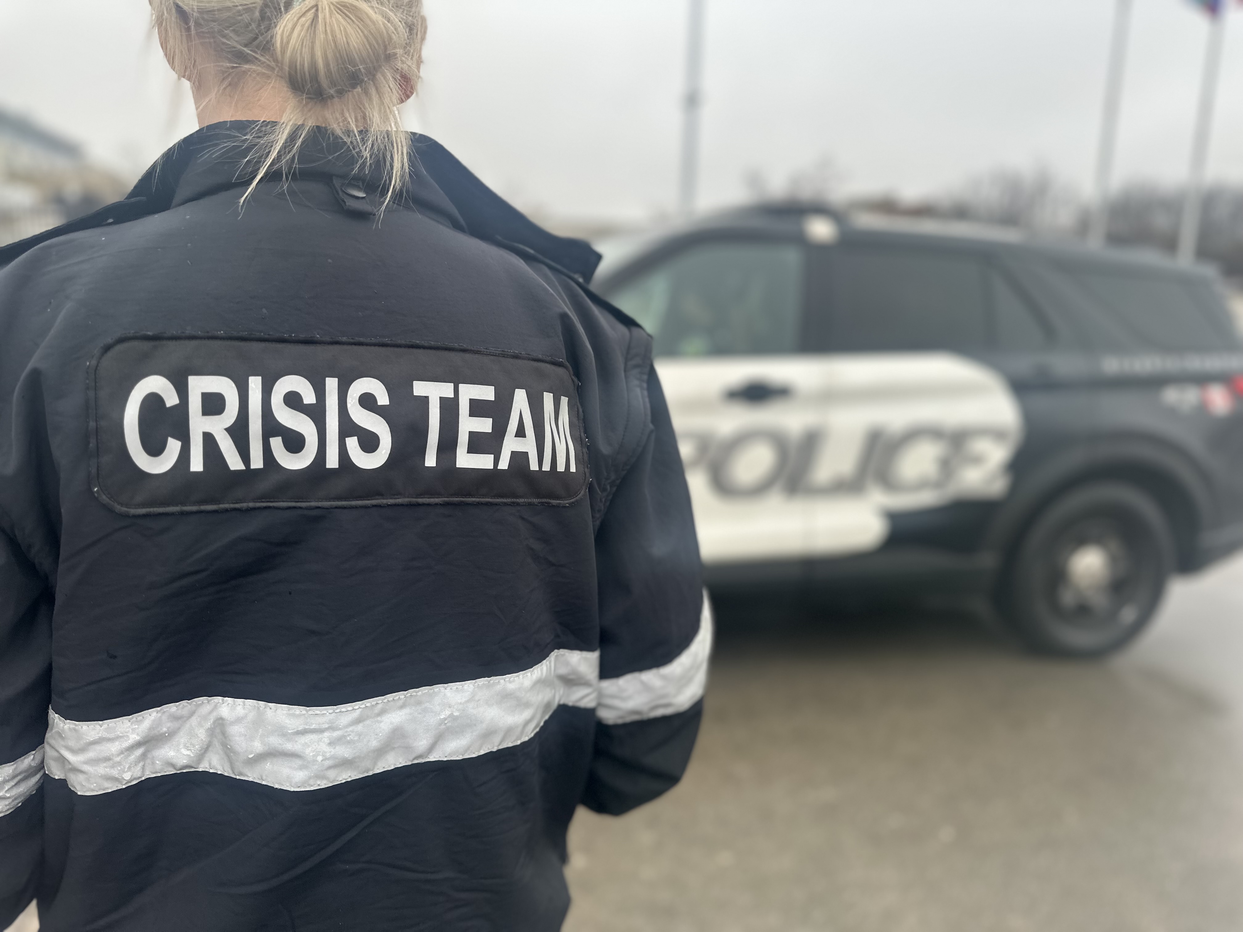 the back of a woman wearing a jacket that says crisis team
