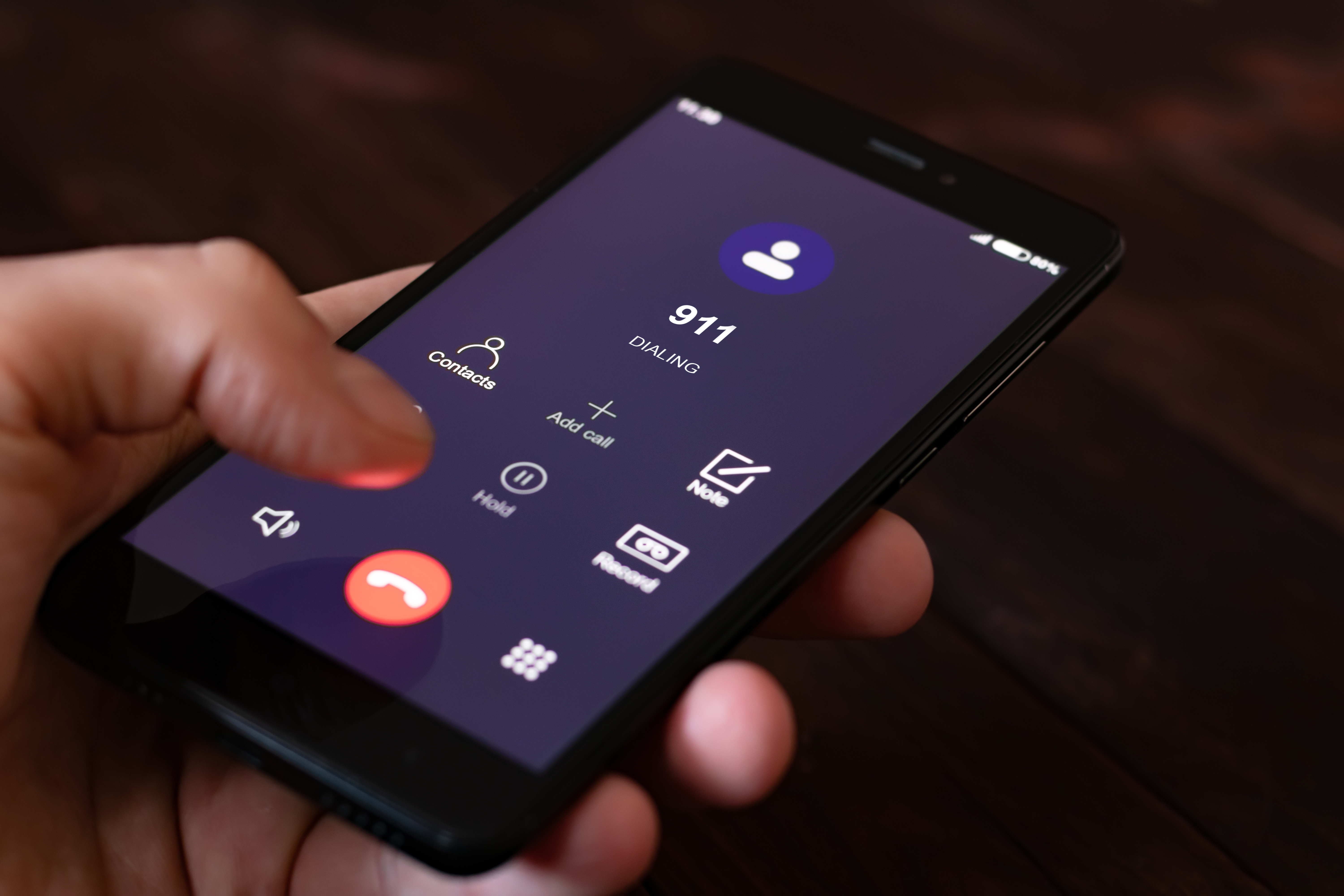 A person dialing 911 on a cell phone